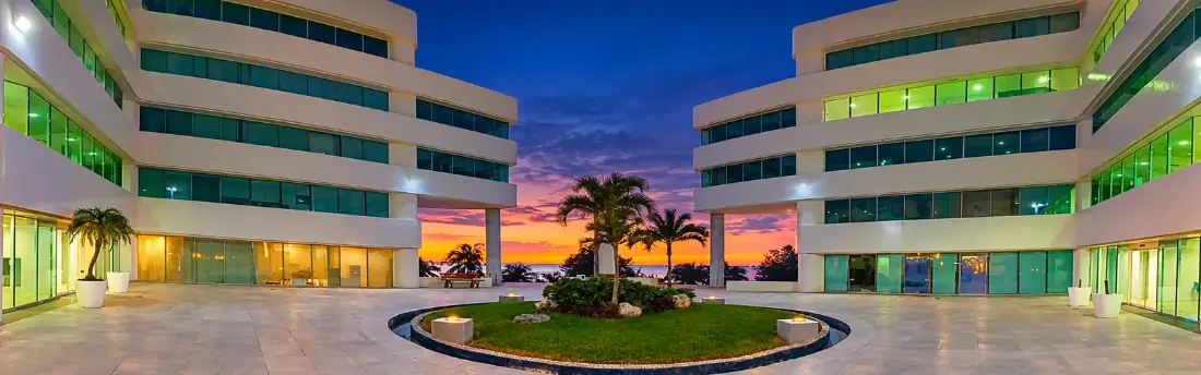 Explanada del Centro Empresarial Cancún al atardecer, edificio donde se ubica el CVDR Unidad Cancún del IPN